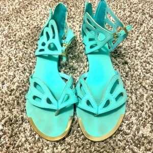 Teal sandals with gold trim. Zip up on the back. Some scuffs on the heels.